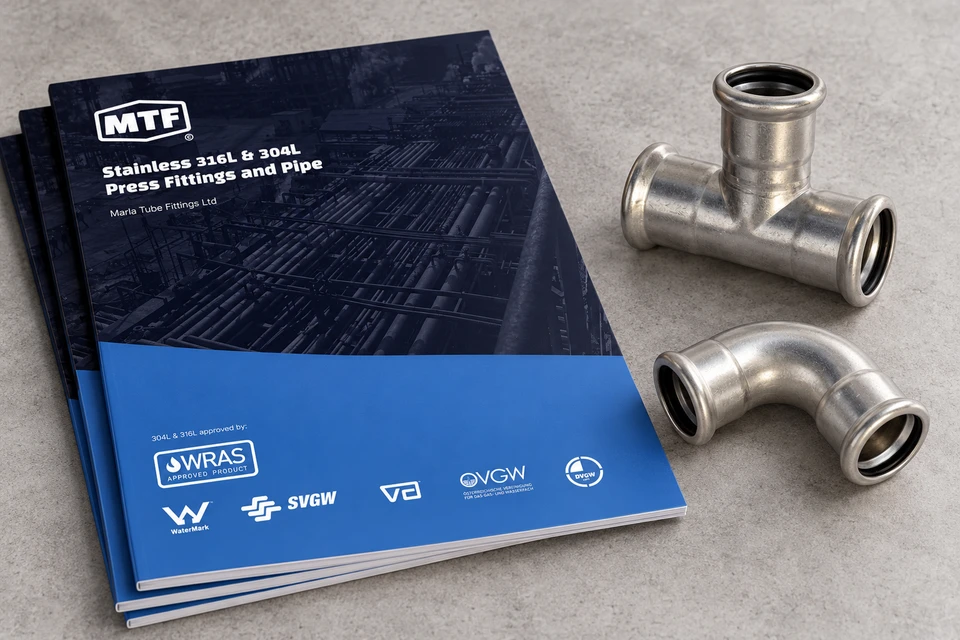 MTF Pressfit brochure beside stainless press fittings.